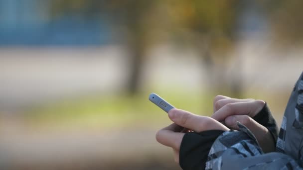Boy Fingers Pressing Phone Screen Playing Video Game Outdoors Autumn — Stock Video
