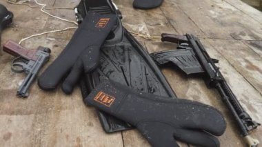 Odessa, Ukrayna - 11 Ekim 2019: Deniz kuvvetleri eldivenleri, tabancalar, uzun yüzgeçler ve yaz aylarında tahta bir köprüde yatan savaş yüzücülerinin makineli tüfeklerinin muhteşem manzarası. İyi ve profesyonel görünüyor.