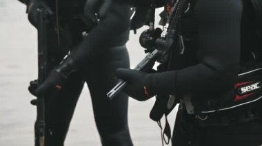 Odessa, Ukrayna - 11 Ekim 2019: Siyah mayo giymiş iki savaş yüzücünün ağır çekimde ellerinde özel silahlar ve otomatik tüfekler bulundurmaları