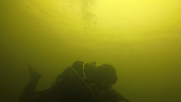 2人の戦闘水泳選手手の武器で緑色の水の中に水中でダイビング黒のスーツ マスクやフリッパーで2人の戦闘水泳の水中ビューを刺激スキューバとスローモーションで緑色の水の中で手の武器で泳ぐ — ストック動画