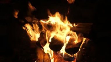Şöminede yanan kırmızı ve sarı alevlerin güzel dilleri yavaş çekimde şömine alevinin neşeli bir görüntüsüyle kütüklere konulmuş ve çok renkli alev çatallarıyla yavaş çekimde oynanıyor. İlham verici ve güzel görünüyor..