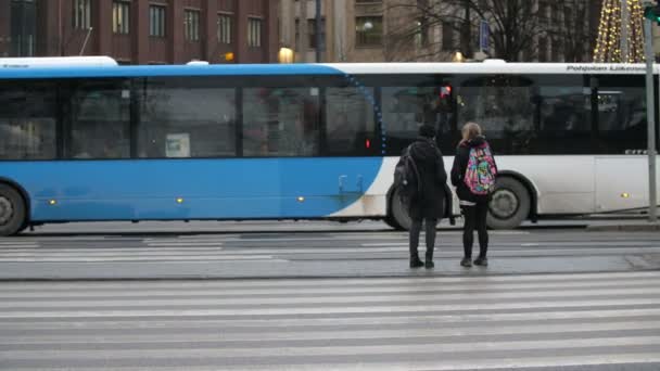 芬兰赫尔辛基 2019年12月12日 令人惊讶的赫尔辛基中央街道景观 乘坐着移动的公共汽车 面包车和卡车 还有几个人在冬季缓慢地等待穿过街道 — 图库视频影像