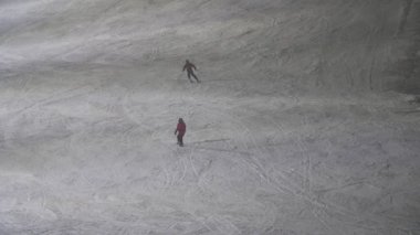İki mutlu turist, Finlandiya 'da yavaş çekimde kar altında kayak yaparak yokuş aşağı kayıyor. İki turist, kar yağışlı kış aylarında Finlandiya' nın Levi kayak merkezinde profesyoneller gibi yokuş aşağı kayıyor.