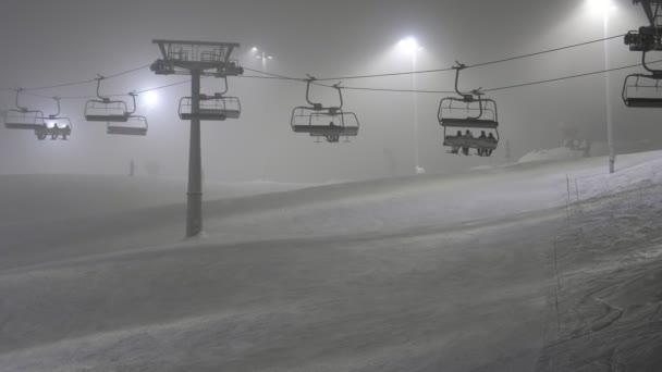快乐的滑雪者在芬兰莱维滑雪胜地的滑雪板上滑行 芬兰莱维滑雪胜地的滑雪板上滑行着欢快的滑雪者 灯柱灯亮着 — 图库视频影像