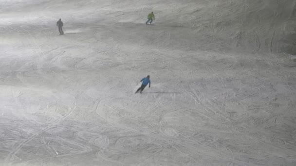 斯纳齐滑雪者在芬兰列维滑雪胜地慢镜头滑向下坡看到快乐的游客在冬夜慢镜头滑落 并在列维滑雪胜地躲闪 他们看起来很活泼 — 图库视频影像