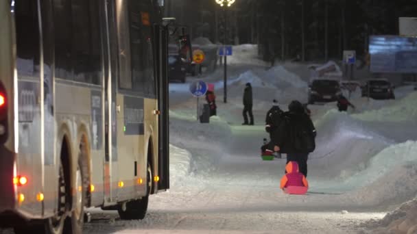 レヴィ フィンランド 2019年12月10日 アクティブな親のエキサイティングな景色雪の冬のレヴィスキーリゾートのモダンなバスから遠くない幸せな子供たちと一緒にそりを歩くと引く — ストック動画
