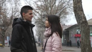 Sonbaharda caddede tutkulu sevgilisiyle sohbet eden mutlu esmer kız güzel bir çiftin sohbet edişinin, gülen ve gülen bir sonbaharda caddede parlayan esmer kız romantik ve şehvetli görünüyor..