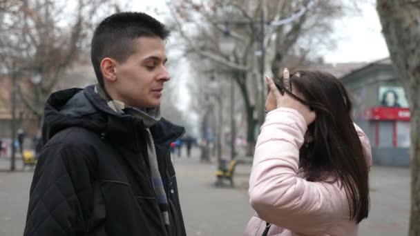 Tatlı Esmer Kız Sonbaharda Gri Sokakta Mutlu Erkek Arkadaşıyla Şakalaşıyor — Stok video