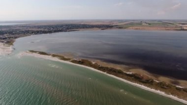 Yazın güneşli bir günde Karadeniz 'de kaygan bir kum şeridinin havadan çekilmiş görüntüsü çarpık bir kum tükürüğünün kuş bakışı görüntüsü. Yazın güneşli bir günde mor sularla birlikte Karadeniz' de uzun bir yay gibi görünen doğal bir arazi..