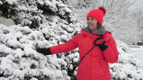 Mujer Sonriente Con Sombrero Rosado Chaqueta Tocando Árboles Nevados Cámara — Vídeo de stock