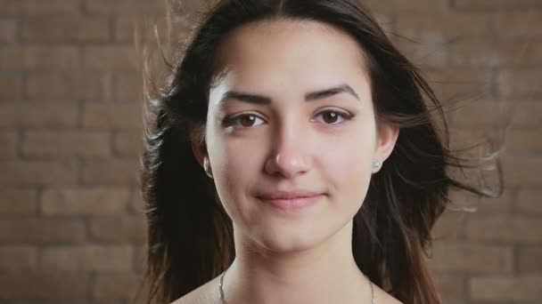 Jovem Morena Alegre Com Cabelo Ondulado Irradiando Estúdio Tijolos Slo — Vídeo de Stock