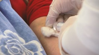 Doktor, Coronavirus hastası bir hastanın damarından kan alıyor. Beyaz üniformalı bir doktorun, Coronavirüs 'ten muzdarip olan bir hastanın eline şırıngadan tıbbi sıvı enjekte edip koğuştaki bir yatakta yatmasına neden oluyor..