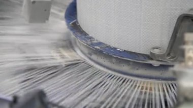 Geniş konik çubuk dönüyor ve modern tarımsal fabrikada büyük plastik tuvaller yapıyor. Geniş bir kolonun görkemli görüntüsü örgü telleri ve birçok metalik iğneyle isyanda bulunuyor. Fabrikada plastik poşet üretimi için büyük beyaz bir tuval üretiliyor.