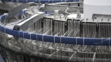 Titreyen plastik kablolarla örgü makinesi fabrikada tarımsal torbalar yapıyor ileri geri titreyen plastik kablolarla etkileyici bir şekilde örgü örüyor modern bir fabrikada tarım çuvalları için plastik teller üretiyor.