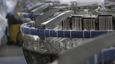Titrek plastik telli örgü cihazı fabrikada tarımsal çuvallar yapıyor. İleri geri sallanan plastik kablolarla örgü ören makinenin yakın çekimini yapıyor. Modern bir fabrikada tarım çuvalları için plastik branda üretiyorlar.