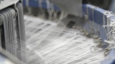 Alelacele çalışan plastik tellere sahip modern makine, atölyedeki tarım çuvalları için plastik doku üreten plastik tellerle ileri geri hareket eden küresel metalik cihazın iyimser bir görünümünde tarım poşetleri üretiyor.