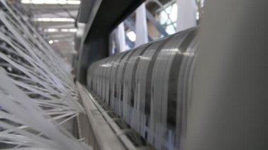 Tarım fabrikasına yerleştirilmiş özel bir makineye bağlanmış birçok beyaz iplik büyük bir tarımsal tesiste bulunan beyaz plastik torbalar üreten özel makinelere sabitlenmiş sayısız beyaz ipliklerin harika görüntüsü..