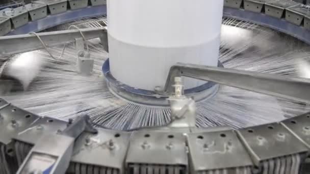 農業工場で大きなプラスチック製のキャンバスを回転させ 編むロフティ円錐形の列編み糸と多くの金属製の針で高尚な列の回転の素晴らしい眺め農業工場でのビニール袋の生産のための大きな白い組織を作る — ストック動画