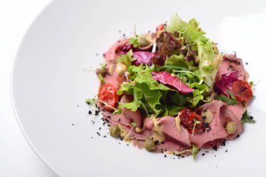 kızartılmış sığır eti, ton balığı ve hamsi soslu salata. İzole