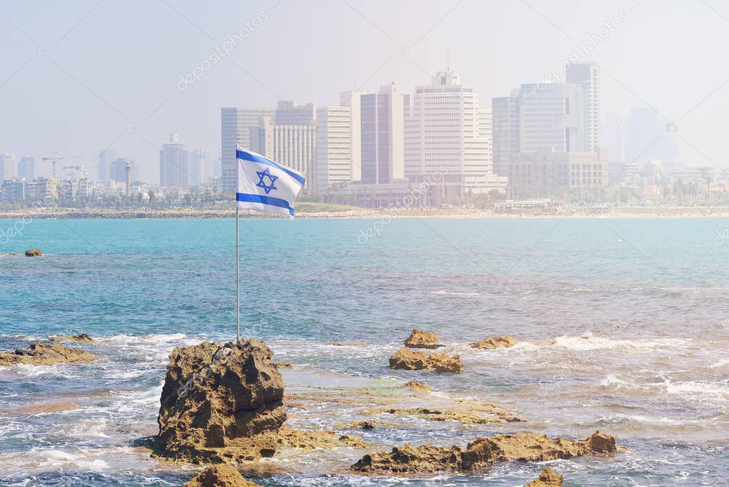 The flag of Israel against the background of modern Tel Aviv