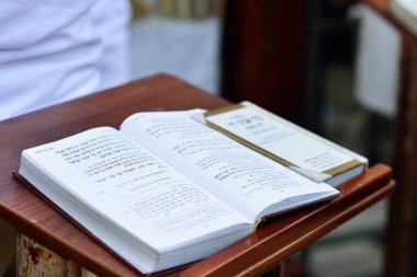 JERUSALEM, ISRAEL - APRIL 2017:  Talmud Tora Tanach Books lying on table during prayer in Bar Mitzwa Ceremony at the Western Wall Jerusalem (Kotel)  clipart