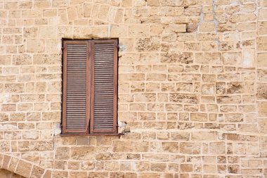 Kapalı bir pencere, eski bir taş duvar.