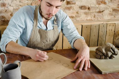 yakışıklı genç Meksikalı potter seramik p çizimler yapar