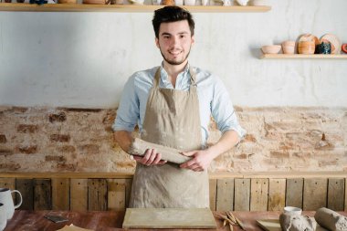 Potter, atölye, Seramik Sanat kavramı - genç esmer ayakta