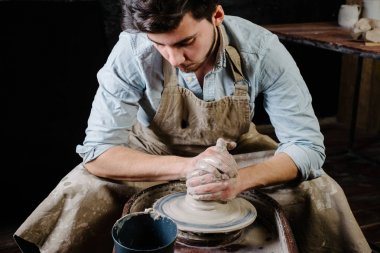 pottery, workshop, ceramics art concept - man working on potter'