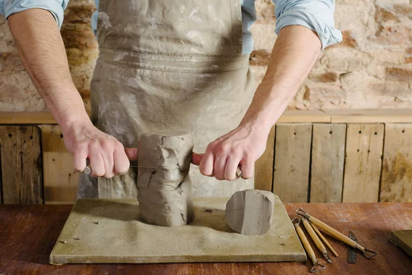 potter, clay workshop, ceramics art concept - male cuts raw clay