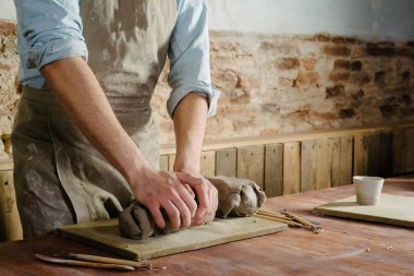 çanak çömlek, kil, Seramik Sanat kavramı - closeup şamot büyük parçaları ile genç ustanın ellerinde