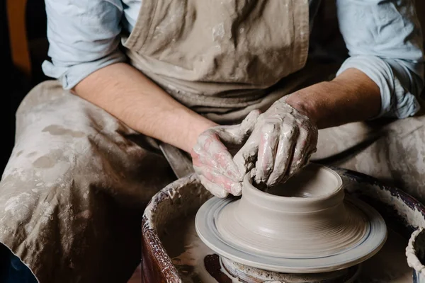 Pottery, workshop, ceramics art concept - closeup on male hands sculpt new utensil with a tools and water, man's fingers work with potter wheel and raw fireclay, front close view — Stock Photo, Image