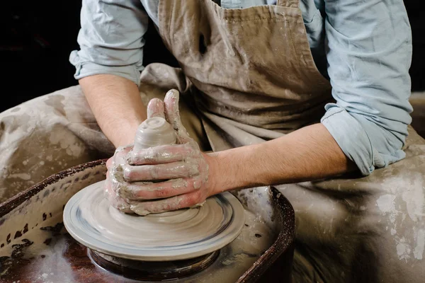 Poterie, atelier, concept d'art céramique - gros plan sur les mains masculines sculpter un nouvel ustensile avec un outil et de l'eau, doigts de l'homme travaillent avec roue de potier et de l'argile crue, vue de près avant — Photo