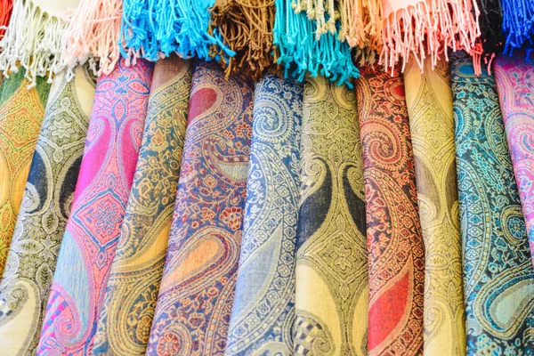 Muchas bufandas y chales femeninos brillantes de cerca en la tienda —  Fotos de Stock