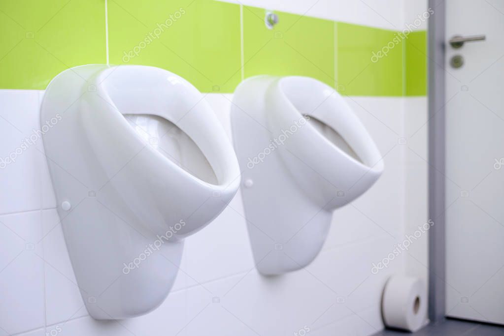 Closeup de urinarios blanco en baño de hombres, diseño de blancos