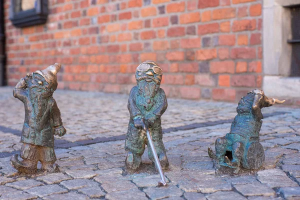 WROCLAW, POLAND - JUNE 17: Disabled dwarfs statues at Wroclaw Market square near Old Town hall. Bronze gnome sculptures are the main tourist attraction and symbol of the city. — Stock Photo, Image