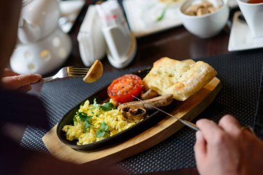 Adam geleneksel İngiliz kahvaltısını bir lokantada yapıyor.