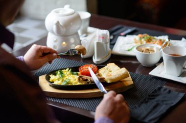 Adam geleneksel İngiliz kahvaltısını bir lokantada yapıyor.