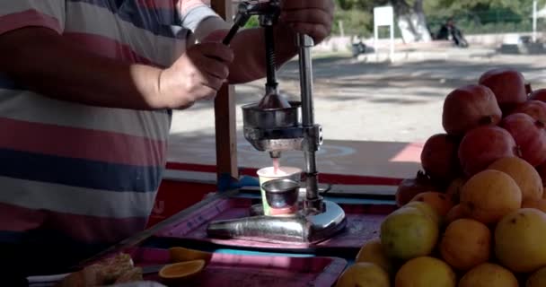 Primer plano del hombre que usa el exprimidor de moda antiguo para hacer jugo de granada — Vídeos de Stock