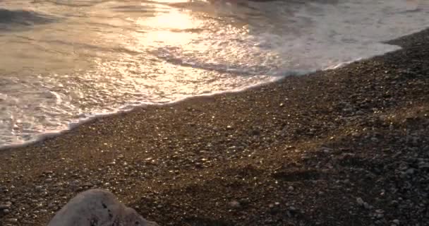 Onde Rolling in su una linea costiera con ascolto e scintillante superficie del mare al tramonto / alba — Video Stock