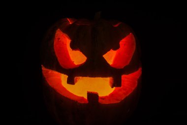 siyah arka plan üzerinde Halloween korkunç yüzünü kabak
