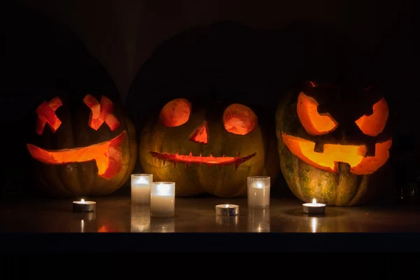 Halloween pumpkins ile korkutucu yüz ve yanan mum siyah b