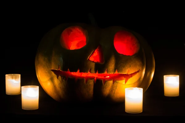 Halloween pumpkins ile korkutucu yüz ve yanan mum siyah b