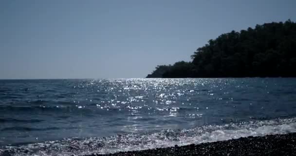 波光粼粼波浪海水是照耀晴朗夏天天与岛剪影 — 图库视频影像