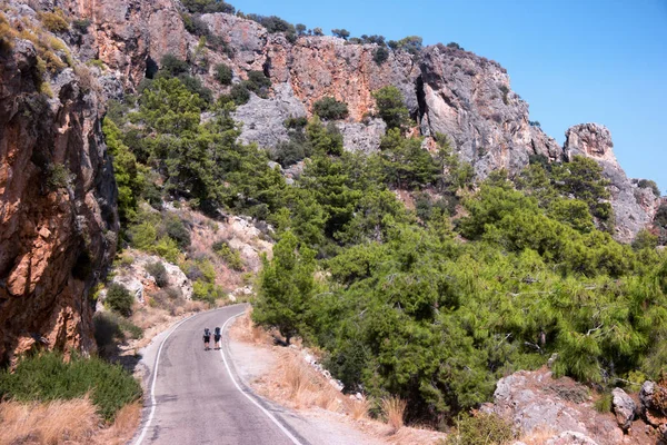 İki genç turist zammı yolun ortasında tarafından gidiş sırt çantaları 