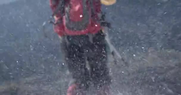 Ein Mädchen mit einem Rucksack reist durch verschneite Berge, während der Wind über den Schnee weht (Schleuderfahrt) — Stockvideo