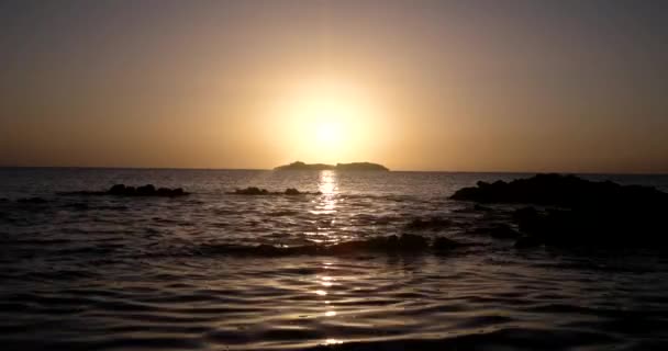 Hermosa vista al amanecer en el mar con silueta de una isla en el horizonte — Vídeos de Stock