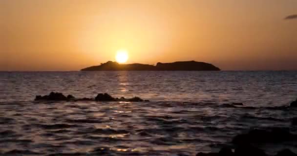 Bela vista do nascer do sol no mar com silhueta de uma ilha no horizonte — Vídeo de Stock