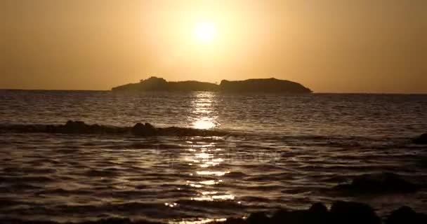 Hermosa vista al amanecer en el mar con silueta de una isla en el horizonte — Vídeo de stock