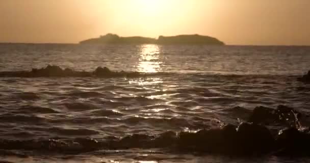 Hermosa vista al amanecer en el mar con silueta de una isla en el horizonte — Vídeos de Stock